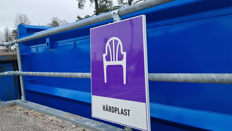 Blå container med lila skylt med texten "hårdplast"