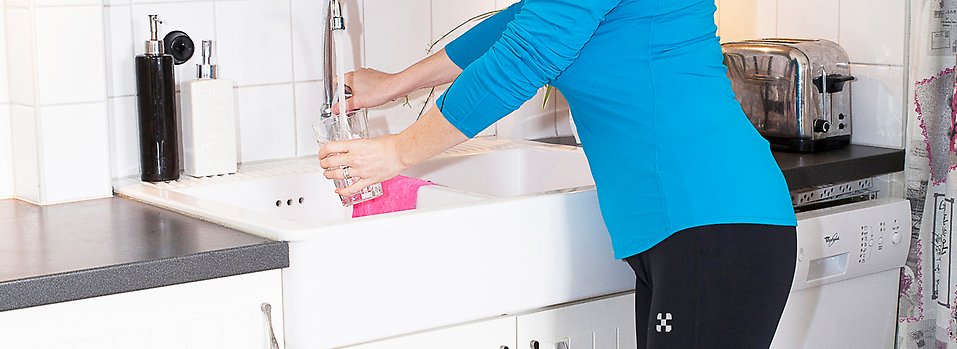 Bild på kvinna som fyller vattenglas